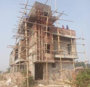 Brickwork and RCC slabs taking shape, with bamboo scaffolding around the building.