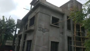 Plastered walls with window grills fitted on a house under construction in Ranchi, ready for painting