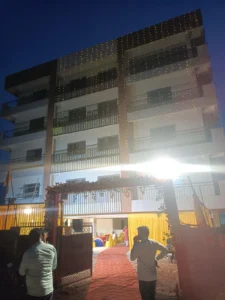 Head office building in Ranchi lit with string lights at night, with flower gate and red carpet for the opening