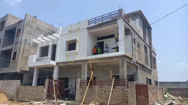 Painting stage of a G+1 house in Argora Ranchi with white primer coat and workers finishing the first-floor balcony