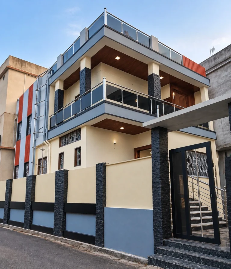 Vastu house construction in Ranchi: duplex home with cream walls, black stone-look columns and glass balcony railing